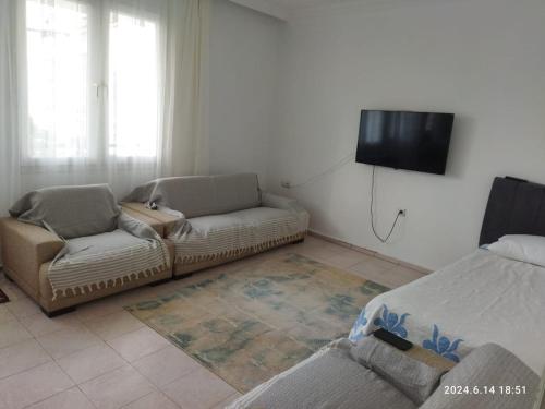a living room with a couch and a flat screen tv at Modern Flat Walk to Shops, Cafes Harbour in Fethiye