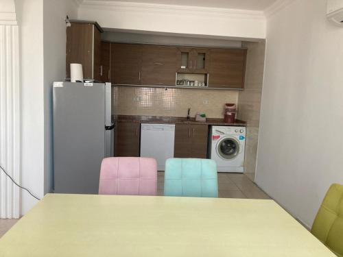 a kitchen with a table and two pink and blue chairs at Modern Flat Walk to Shops, Cafes Harbour in Fethiye