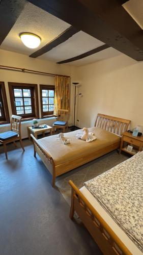 a bedroom with two beds and two tables and chairs at Hotel im Hochzeitshaus in Schotten