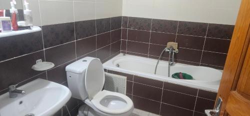 Un baño con inodoro, lavabo y bañera. en une chambre, un salon, cuisine et balcon, en Monastir