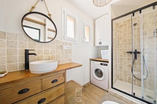 une salle de bain avec un lavabo et une machine à laver dans l'établissement Le Phare Giens CLIM/WIFI/PARKING, à Hyères