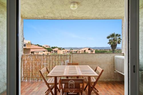 un patio avec une table et des chaises sur un balcon dans l'établissement Le Phare Giens CLIM/WIFI/PARKING, à Hyères