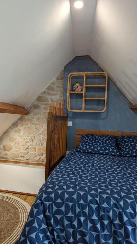 - une chambre mansardée avec un lit bleu dans l'établissement Maen bihan, à Arzon
