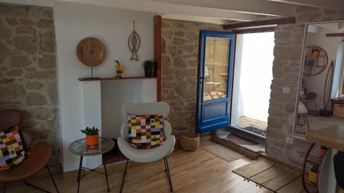 une chambre avec deux chaises et une porte bleue dans l'établissement Maen bihan, à Arzon