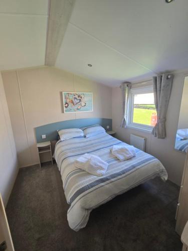 a bedroom with a large bed with towels on it at 6 Birth Caravan Quay West Sea Views in New Quay