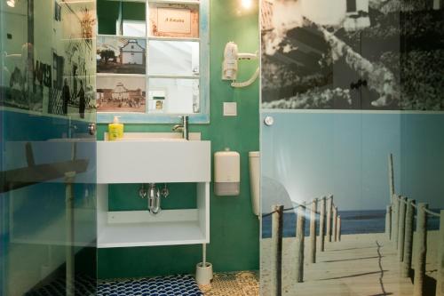 a bathroom with a sink and a mirror and stairs at Casas da villa - Apartments in Ericeira