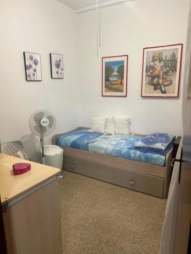 Un dormitorio con una cama y cuadros en la pared. en A Casa di Elisa, en Torre Santa Sabina