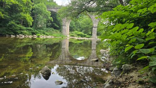 een brug over een rivier met een reflectie in het water bij Maison Essentielle in Tournon-sur-Rhône