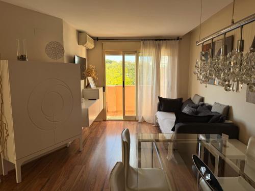 a living room with a couch and a glass table at Encantador Ático a 2,6 km de la Playa in San Juan de Alicante