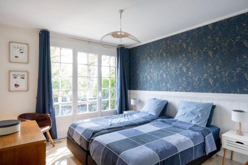 une chambre avec un lit et un mur bleu dans l'établissement 'Maison Bellevue', à Corancy