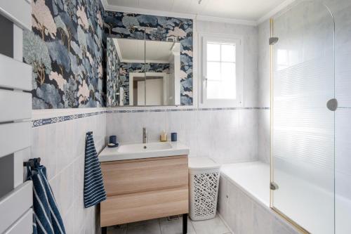 une salle de bain avec un lavabo, une baignoire et un miroir dans l'établissement 'Maison Bellevue', à Corancy