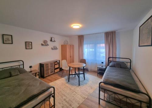 a bedroom with two beds and a table and a desk at Residence Apartments in Bietigheim-Bissingen