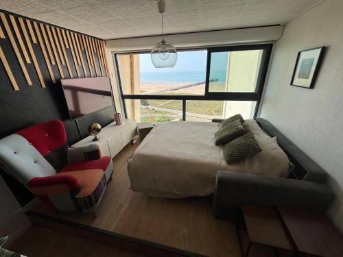 une chambre avec un lit, un canapé et une fenêtre dans l'établissement Fabuleux Face Mer 9ème étage, à Saint-Jean-de-Monts