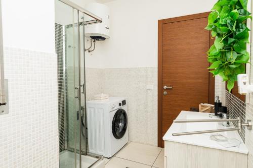 a bathroom with a washing machine and a glass door at Appartment - Joile Maisone in Porto Torres