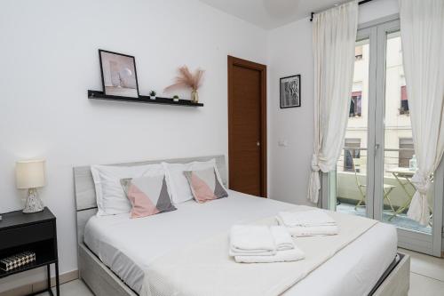 a bedroom with a white bed with towels on it at Appartment - Joile Maisone in Porto Torres