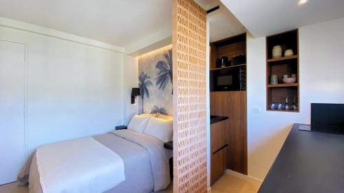 une chambre avec un lit blanc et une télévision dans l'établissement Cannes Croisette, à Cannes