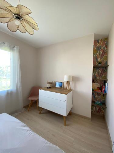 - une chambre avec un lit, une commode et un ventilateur de plafond dans l'établissement Maison Île d'Oléron - 6 personnes 3 chambres, au Château-dʼOléron