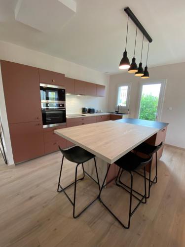 une cuisine avec une table en bois et deux chaises dans l'établissement Maison Île d'Oléron - 6 personnes 3 chambres, au Château-dʼOléron