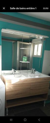 une salle de bain avec deux lavabos et un grand miroir dans l'établissement Villa avec piscine et jacuzzi privé, à Saint-Clair-dʼArcey