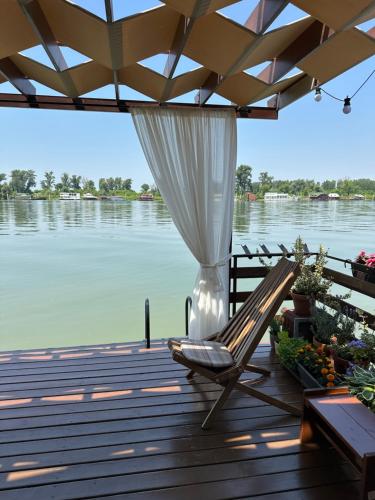 a deck with a chair and a view of the water at Splav na Savi in Ostružnica