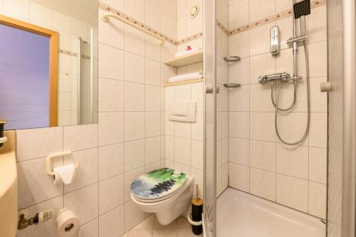 a bathroom with a shower with a toilet and a sink at Green Wellness Pools Saunas Appartement with Alpine view Terrace in Sankt Englmar