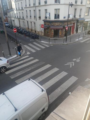une camionnette blanche garée à un passage piéton dans une rue de la ville dans l'établissement Studio familial, à Paris