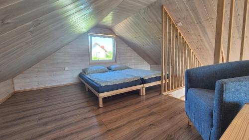 a small bedroom with a bed in a attic at Letni Spokój II in Wynki