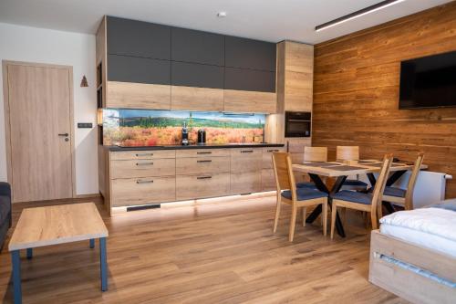 a kitchen and dining room with a table and a bedroom at Apartmán Maruška in Dolní Morava