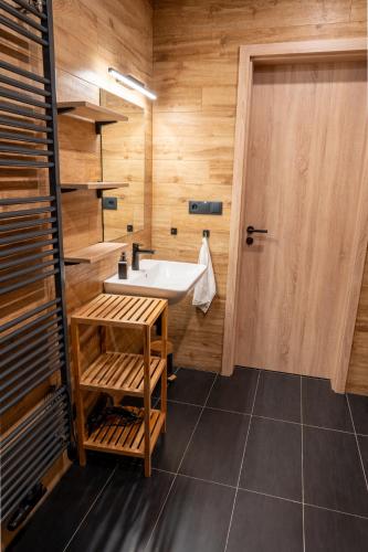 a bathroom with a sink and a wooden wall at Apartmán Maruška in Dolní Morava