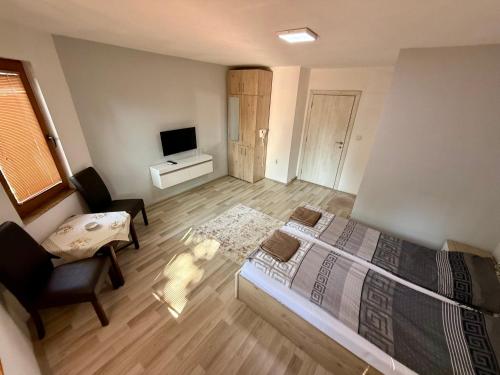 a bedroom with a bed and a chair and a television at Han Hotel and Lounge Connect- Chair in Skopje