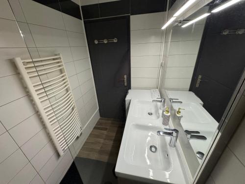 une salle de bain avec deux lavabos et un miroir dans l'établissement Fabuleux Face Mer 9ème étage, à Saint-Jean-de-Monts