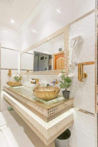 a bathroom with two sinks and a large mirror at Makeen Homes ApartHotel in Riyadh