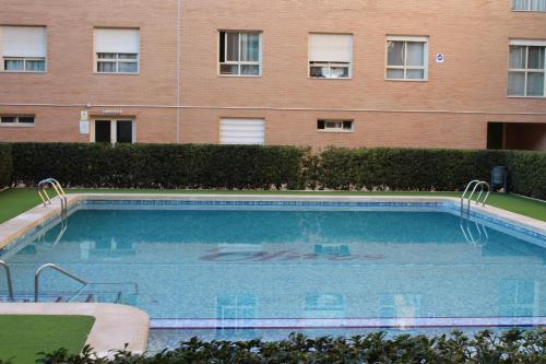 a large swimming pool in front of a building at Encantador Ático a 2,6 km de la Playa in San Juan de Alicante