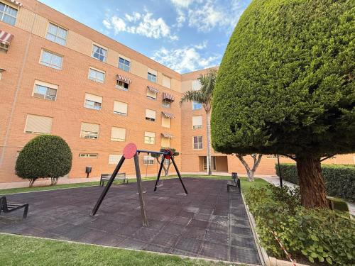 a playground in front of a large building at Encantador Ático a 2,6 km de la Playa in San Juan de Alicante