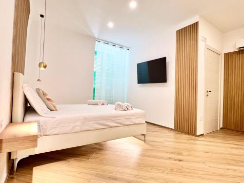 a bedroom with a bed and a tv on a wall at Eden Suite Apartaments in Molfetta