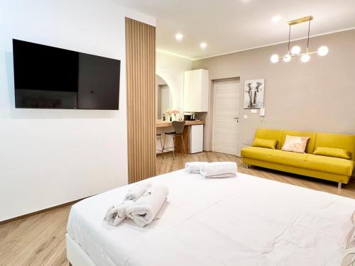 a bedroom with a bed and a yellow couch at Eden Suite Apartaments in Molfetta