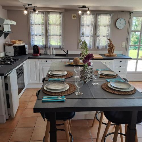 une cuisine avec une table avec des assiettes et des verres à vin dans l'établissement Le Coze, à Saint-Martial-de-Nabirat