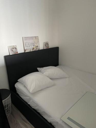 - un lit blanc avec 2 oreillers dans l'établissement Appartement vue mer, à Saint-Hilaire-de-Riez