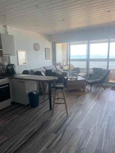 une cuisine et un salon avec une table et des chaises dans l'établissement Appartement vue mer, à Saint-Hilaire-de-Riez