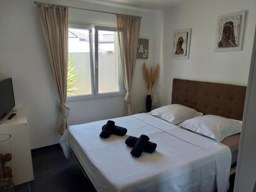 - une chambre avec un lit et 2 serviettes noires dans l'établissement Villa 6 personnes piscine chauffée, à Saint-Aunès