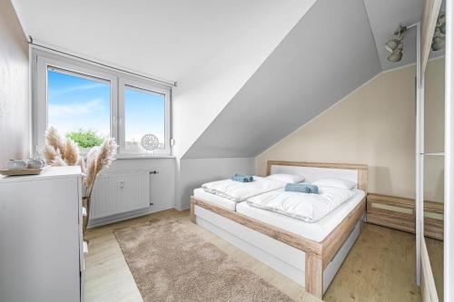 a white bedroom with a bed and a window at Messe DUS, Parken, 3 Zimmer, 70qm in Duisburg