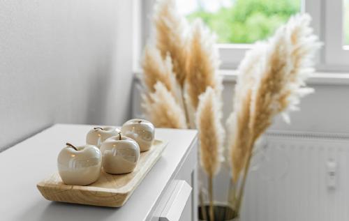 a table with three apples and a vase of wheat at Messe DUS, Parken, 3 Zimmer, 70qm in Duisburg