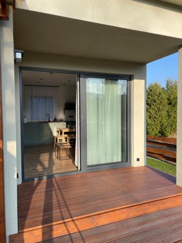 an open deck with a view of a house at Domek Na Miodowej in Sulistrowiczki