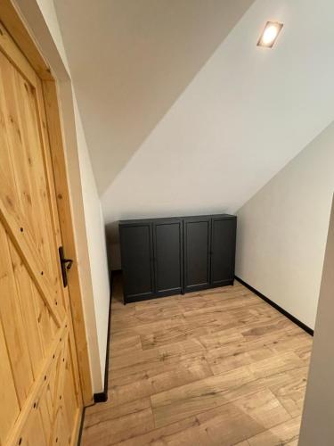 a room with black cabinets and a door at Domek Na Miodowej in Sulistrowiczki