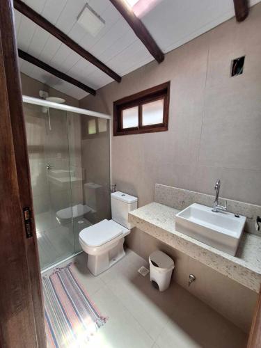 a bathroom with a toilet and a sink and a shower at Casa Paiol loft no centro do Arraial in Arraial d'Ajuda