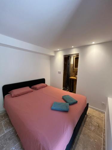 a bedroom with a bed with two blue towels on it at PierrAnge in Grillon