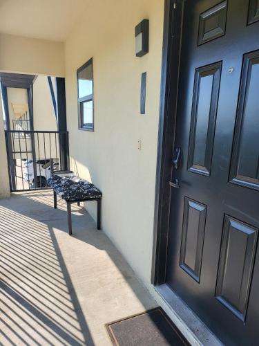 a door to a house with a bench on the porch at The WorkNest Stylish Stay w Desk & Fast Wi-Fi in Laredo