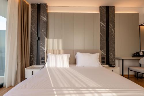 a bedroom with a large white bed with two pillows at Nobbu Hotel Ksamil in Ksamil