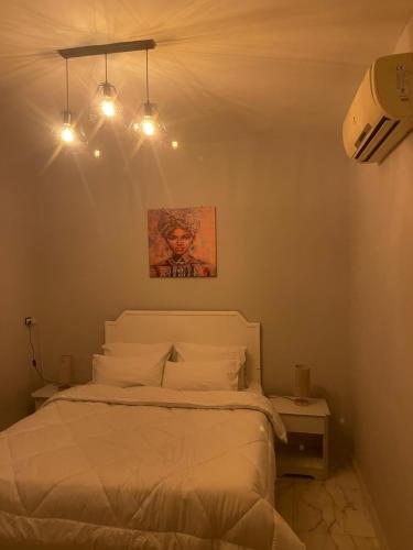 a bedroom with a white bed with lights above it at Doody Cozy chalet in Dahab