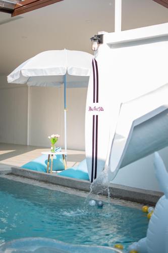 a pool with a water fountain in a hotel room at Mina Pool Villa in Ban Huai Yai